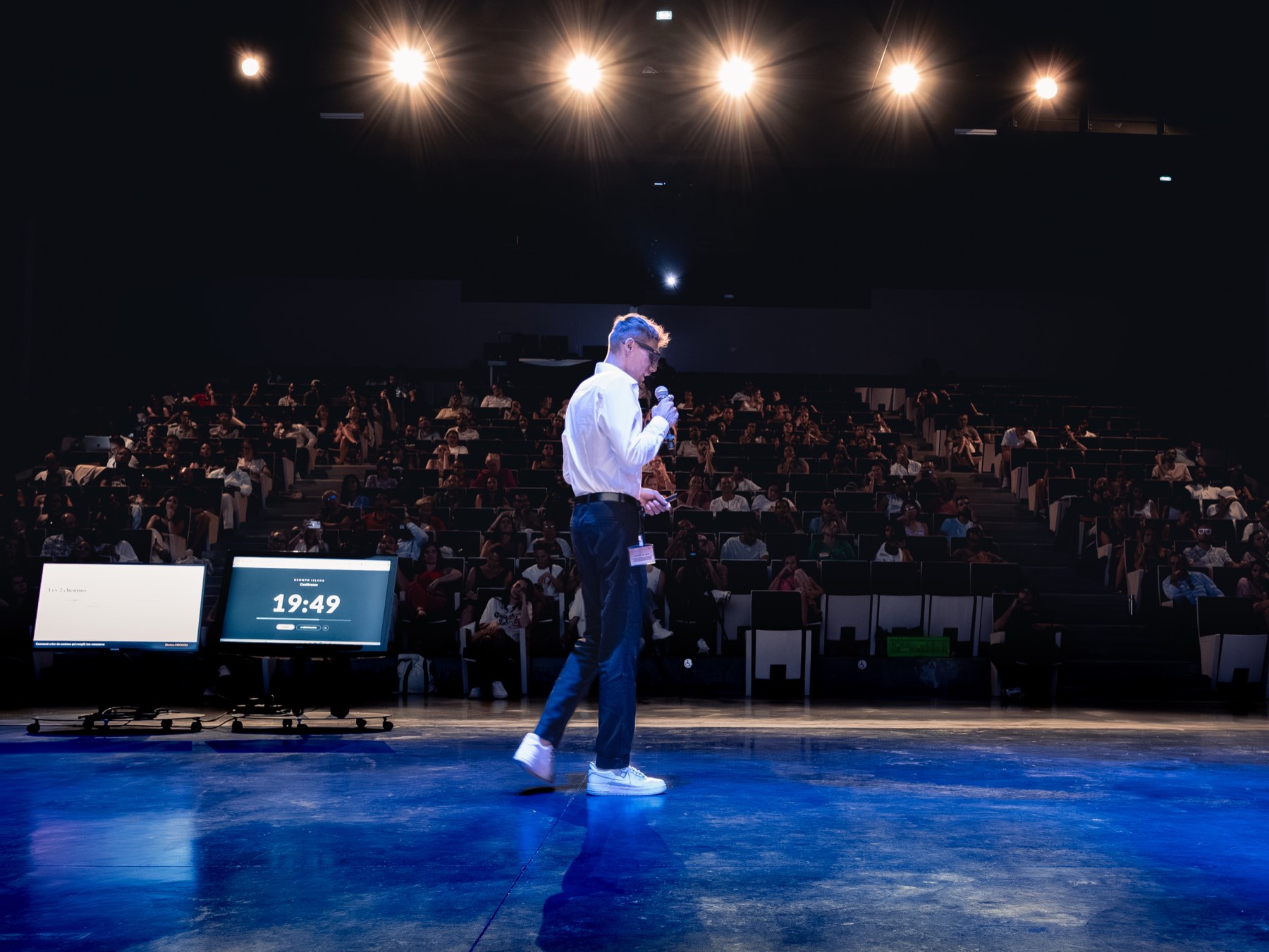 Siméon sur scène, micro en main, devant une salle pleine